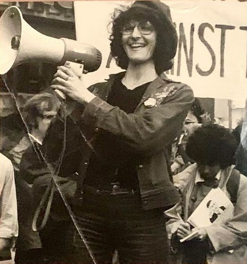 Naomi Binder Wall smiling and holding a megaphone