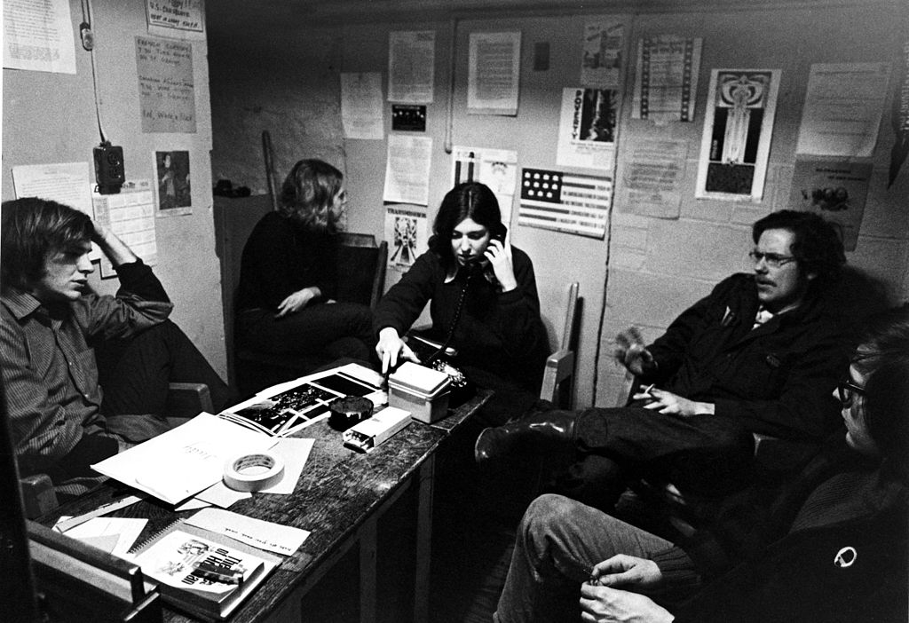 Black and white photograph of five young people in a small room.