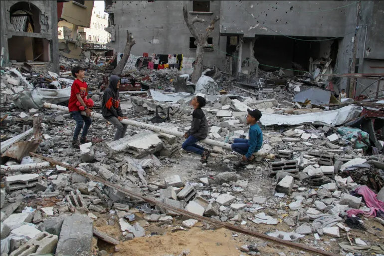 Children playing on make-shift teeter-totter in the ruins, Gaza.